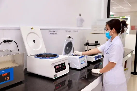 Kỹ thuật viên sử dụng máy ly tâm xử lý mẫu
